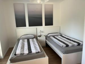 two beds in a room with two windows at Ferienhaus Heideidyll in Bispingen