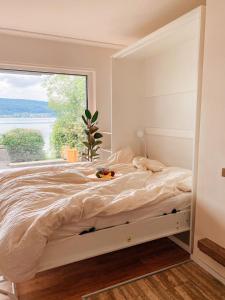 a bedroom with a large bed with a large window at Ferienwohnung Findling in Reichenau