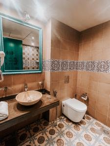 a bathroom with a sink and a toilet and a mirror at Layali Al Shams Hotel in ‘Anjar