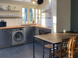 a kitchen with a table and a washing machine at Southfield Art Studio in Braunston