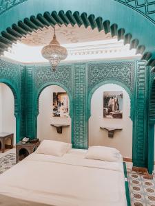 فندق ليالي الشمس  في عنجار: غرفة نوم بسرير وجدران خضراء وبيضاء
