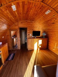 Zimmer mit einem TV und einer Holzdecke in der Unterkunft The Hobbit Bungalow in Da Lat
