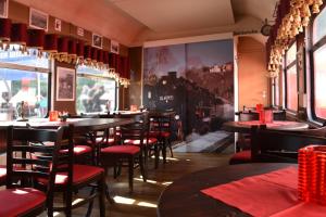 a restaurant with tables and chairs and a train on the wall at Wolkensteiner Zughotel in Wolkenstein