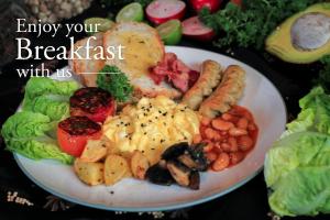 a plate of breakfast food on a table at Grandmas Plus Hotel Seminyak in Seminyak