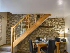 une salle à manger avec une table en bois et un escalier dans l'établissement Greenview, à Nawton