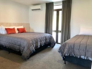 a bedroom with two beds and a window at The Bealey Hotel in Arthur's Pass