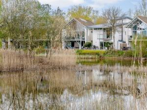 a house with a pond in front of it at Honey Cottage in Somerford Keynes