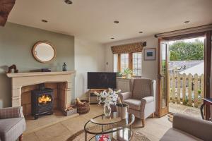 a living room with a fireplace and a tv at Squirrel Barn in Moreton in Marsh