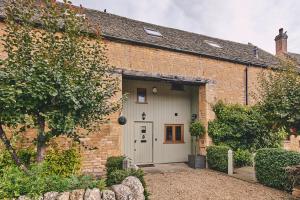 a brick building with a garage with a door at Squirrel Barn in Moreton in Marsh