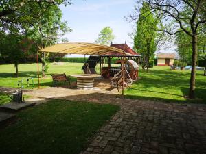 einen Pavillon mit Spielplatz in einem Park in der Unterkunft Tóbiás Tanya Vendégház in Hódmezővásárhely