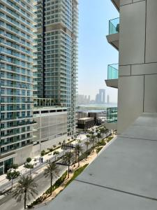 uma vista a partir da varanda de um edifício com palmeiras em Stunning 1BR Apt high floor with palm view & private beach at EMAAR Beachfront em Dubai