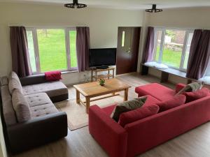 a living room with two red couches and a tv at Anni Puhkebaas in Meeliku