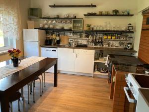 a kitchen with white appliances and a wooden floor at Anni Puhkebaas in Meeliku