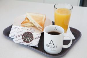 uma bandeja com um prato de pequeno-almoço com uma chávena de café e torradas em Love Croatia Hostel-Mir Guesthouse Zagreb em Zagreb