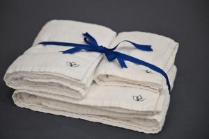 une pile de serviettes avec un ruban bleu sur elles dans l'établissement Behome202, à Fisciano