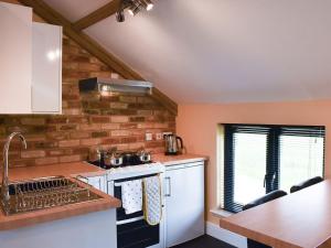 a kitchen with a white stove top oven next to a counter at Pilgrims Barn in Hitcham