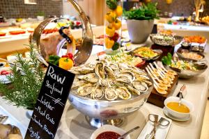 a buffet of food with oysters and other foods at Holiday Inn & Suites Saigon Airport, an IHG Hotel in Ho Chi Minh City