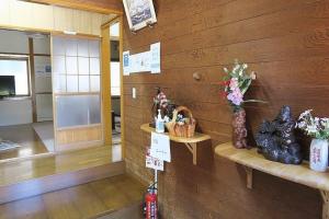 um quarto com uma parede de madeira com um banco e flores em FUJI新倉山 em Azagawa