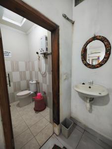 ein Bad mit einem Waschbecken und einem WC in der Unterkunft Pondok Dewi in Pangandaran