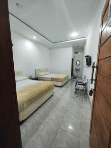 um quarto de hotel com duas camas e uma televisão em Pondok Dewi em Pangandaran