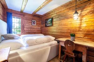 a bedroom with a bed and a wooden wall at Bergchalet Schennaberg in Schenna