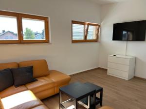 ein Wohnzimmer mit einem Sofa und einem Flachbild-TV in der Unterkunft Apartment Vienna Family Suite in Wien