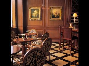 a restaurant with tables and chairs and portraits on the wall at Market Pavilion Hotel in Charleston