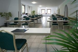una fila di tavoli e sedie in una stanza di Hotel Sophienhof a Königs Wusterhausen