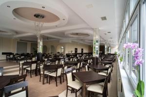 a restaurant with wooden tables and chairs and flowers at Centrum Promocji Zdrowia Sanvit in Iwonicz-Zdrój