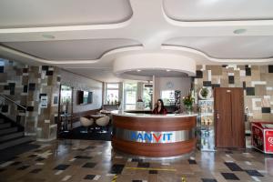 a woman standing at a bar in a hotel lobby at Centrum Promocji Zdrowia Sanvit in Iwonicz-Zdrój