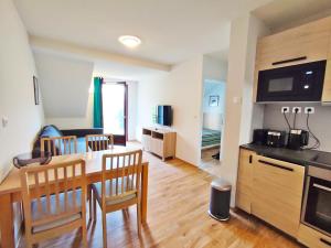 a kitchen and living room with a table and chairs at Le Flocon, T2, vue montagne, parking gratuit, 4 personnes in Luchon