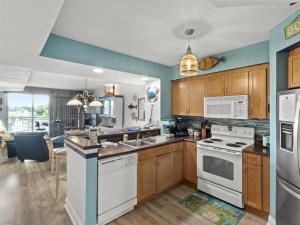 a kitchen with wooden cabinets and white appliances at Harbourgate Marina #312 in Myrtle Beach