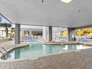 a swimming pool with blue chairs in a building at Harbourgate Marina #312 in Myrtle Beach