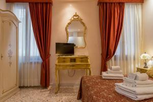 1 dormitorio con espejo y mesa con toallas en Angeles Inn, en Venecia