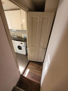 een hal die leidt naar een keuken met een deur bij 43 Kimberly road apartment in Londen