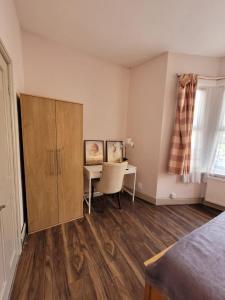 a bedroom with a desk and a cabinet and a table at 43 Kimberly road apartment in London