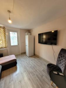 een woonkamer met een koelkast en een tafel en stoelen bij 43 Kimberly road apartment in Londen