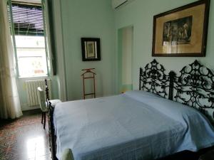 1 dormitorio con 1 cama grande con colcha blanca en Villa Manasse, en Aci Castello