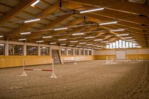 une grande pièce avec des étals pour chevaux dans l'établissement Astoria Hotel & Restaurant, à Gheorgheni
