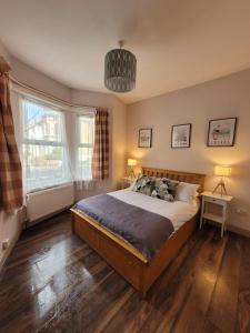 een slaapkamer met een groot bed en 2 ramen bij 43 Kimberly road apartment in Londen