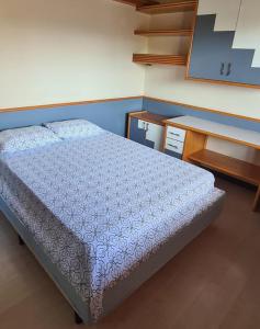 a small bedroom with a bed and a desk at Theora Quarto Amora in Blumenau