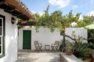 a patio with chairs and a green door at Casa Julia in La Laguna