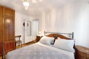 a bedroom with a bed with white sheets and a chandelier at Orizzonte Calmo in Borghetto Di Borbera