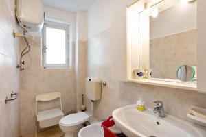 ein Badezimmer mit einem WC, einem Waschbecken und einem Spiegel in der Unterkunft Orizzonte Calmo in Borghetto Di Borbera