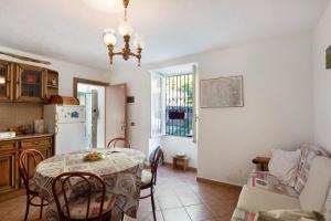 a kitchen and dining room with a table and a refrigerator at Orizzonte Calmo in Borghetto Di Borbera