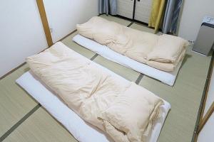 two beds sitting on the floor in a room at FUJI新倉山 in Azagawa
