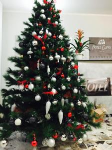 a christmas tree with christmas ornaments on it at Hotel Capri in Diano Marina