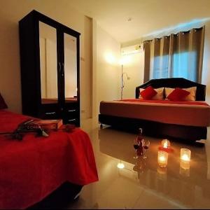 1 dormitorio con 2 camas y velas en el suelo en Orchidilla Residence Phuket Mai Khao Beach - SHAPlus, en Mai Khao Beach