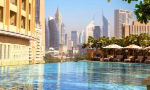 a swimming pool with a city skyline in the background at Emaar Fashion Avenue - Formerly Address Dubai Mall Four Apple in Dubai
