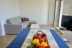 un soggiorno con un cesto di frutta su un tavolo di The Blue - lake / city view modern apt near villa Olmo a Como
